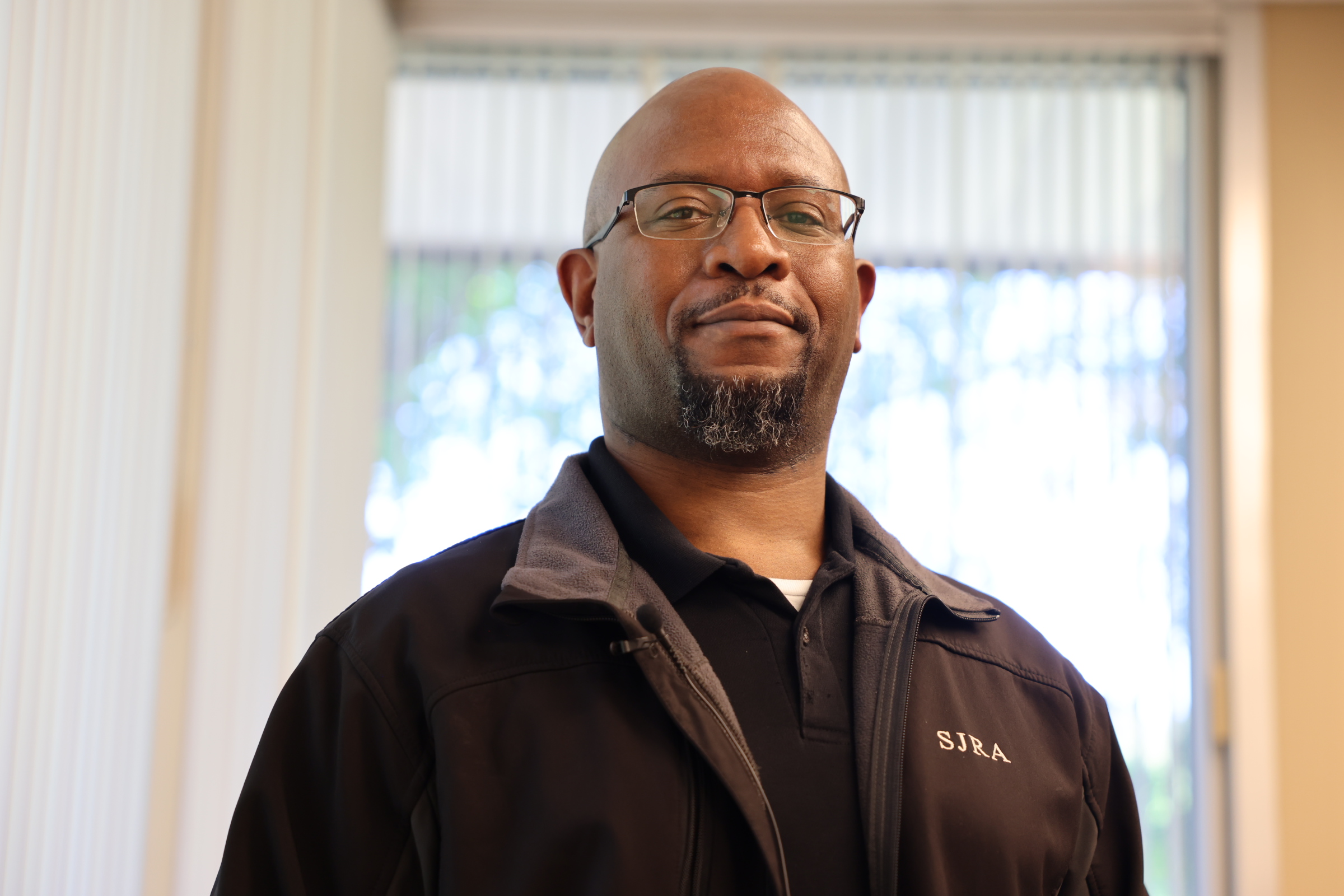 Ed Coleman Male with glasses, wearing a brown SJRA jacket